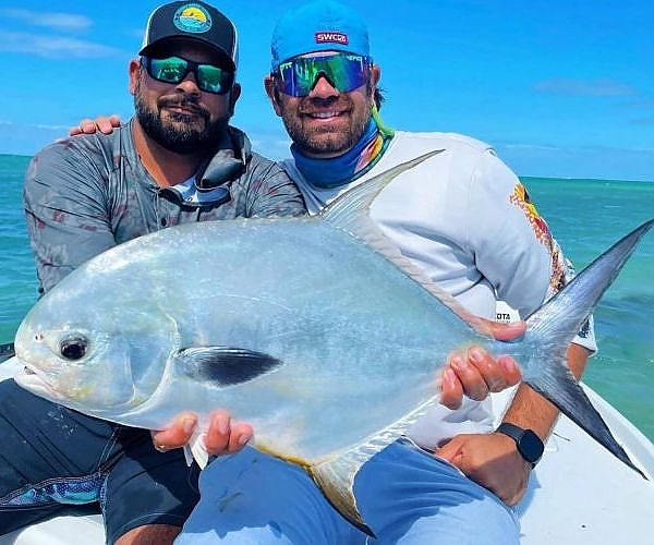 Two fishermen pose with their catch.