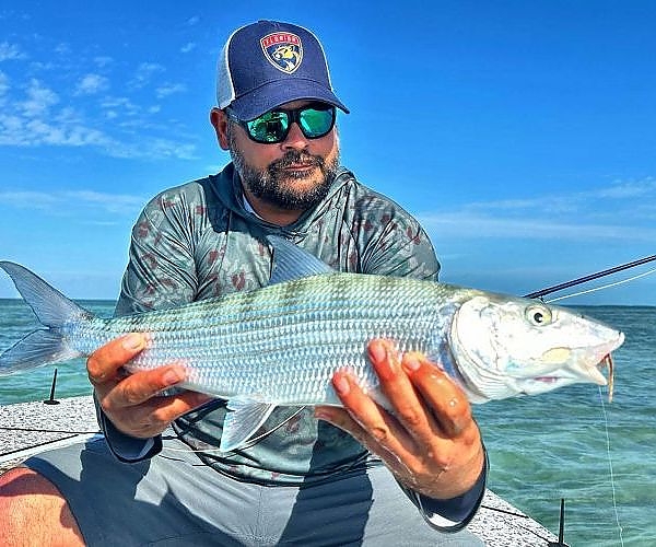 Fisherman holds up his catch for the camera